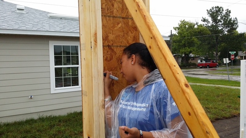 Maria's daughter writes a note of her own on the frame of her new home. photo credit: Habitat for Humanity