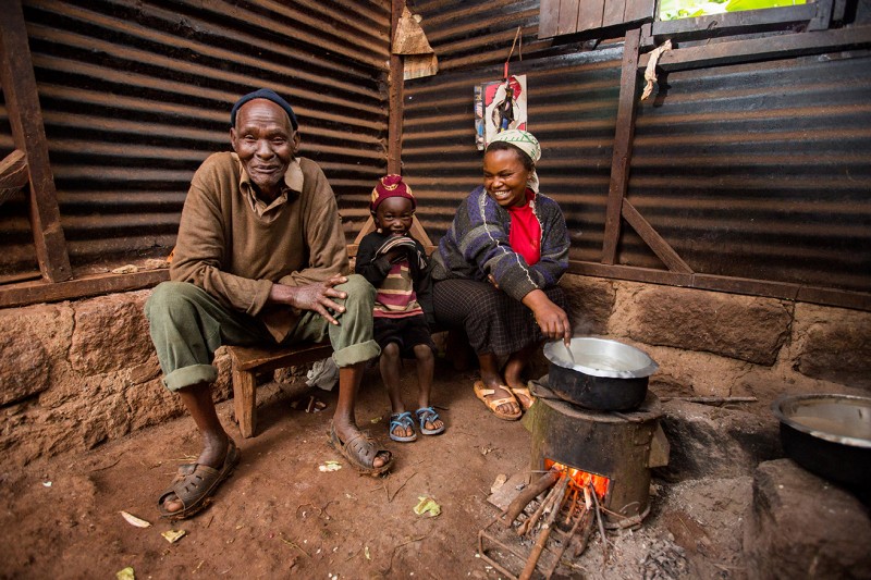Mary, a mother from Kenya, cooking with her family using her brand new fuel-efficient stove.