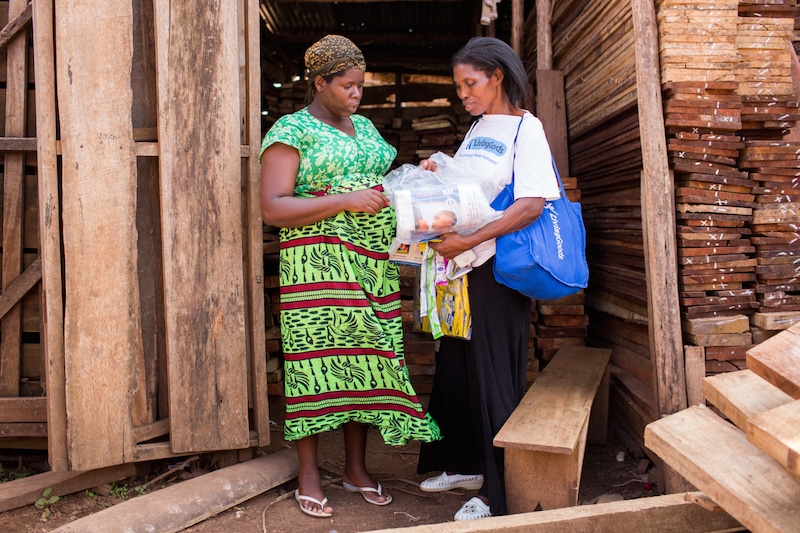 Joy, a health care promoter working in Uganda with one of her repeat customers.